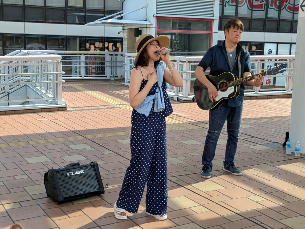海老名ストリートライブで歌うのんとギターを演奏するみっちぃ