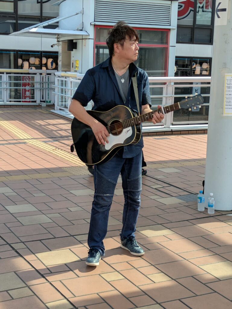 海老名ストリートライブでアコースティックギターを演奏するみっちぃの全身写真